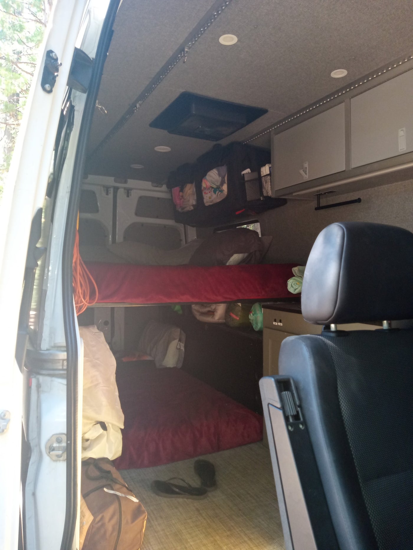 RV rental interior: stacked bunk beds, storage, & open door view. A comfortable mobile home ready for adventure! — photo 13