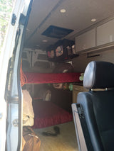 RV rental interior: stacked bunk beds, storage, & open door view. A comfortable mobile home ready for adventure!