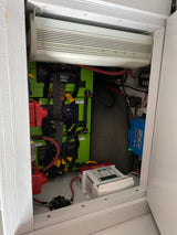 Inside an RV rental cabinet: inverter, lithium batteries, solar charge controller, and power management for off-grid travel.