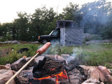 Roasting a hot dog over a campfire while camping with an overlanding vehicle and rooftop tent, ideal for an RV rental adventure.