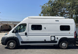 White high-roof camper van with utility ports, perfect for your next RV rental adventure.