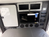 RV rental interior with a 32" Smart TV, JBL audio system, and a control panel for switches, above a gray bed area.