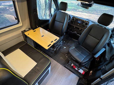RV rental interior: Swiveled front seats, an adjustable wood table, and comfy bench seating create a functional living space.