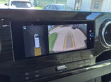 Inside an RV rental, the dashboard screen displays both a backup camera view and parking assist sensor data for easy maneuvering.