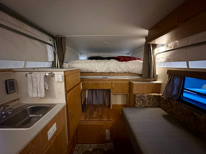  with a river flowing nearby.|RV rental interior: A compact — photo 9