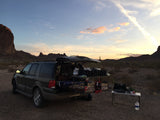 Desert sunset car camping in an SUV with a customized bed and kitchen. A practical RV rental alternative for adventure.