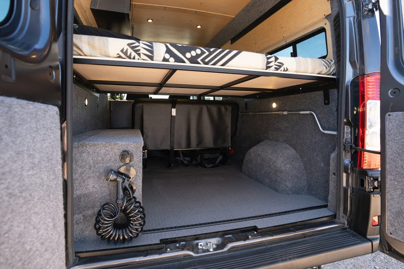  pull-out induction cooktop. This compact kitchen appliance maximizes space for gourmet camping.|RV rental: Compact camper kitchen with open fridge — photo 14