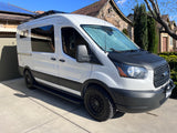 White Ford Transit camper van conversion, featuring solar panels, rugged tires, and a black hood. Perfect for an RV rental adventure.