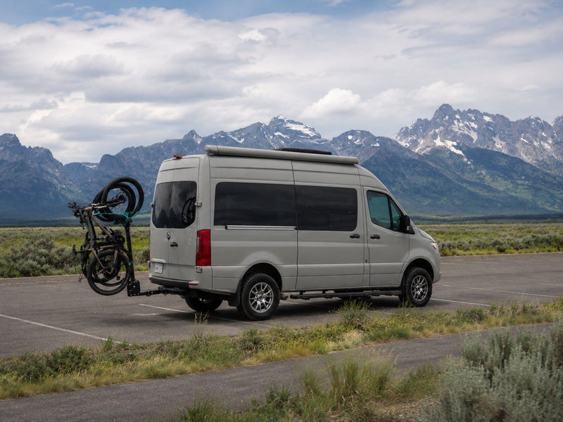 RV rental camper van with bike rack parked by scenic mountains under a cloudy sky. Perfect for an adventure getaway!|Serene rv rental morning: two lattes on a countertop — photo 1