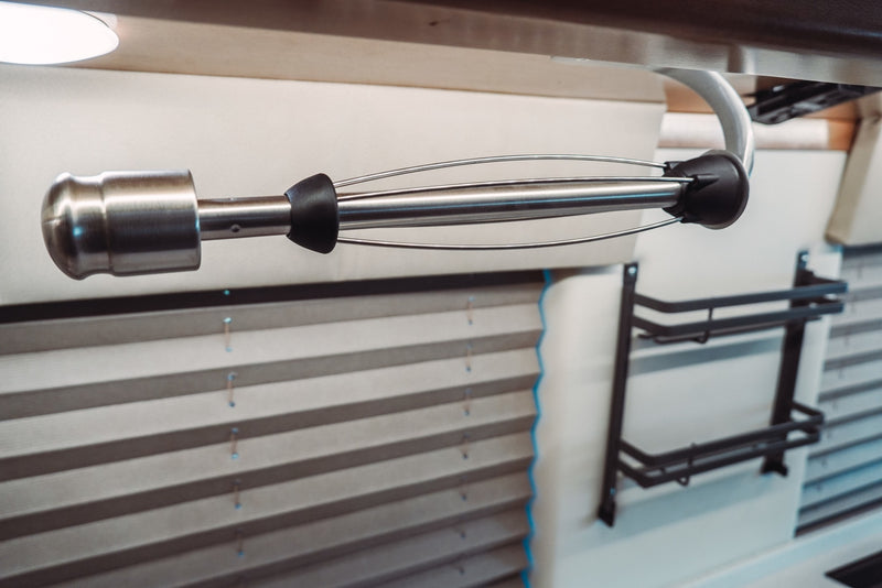RV rental interior shows a stainless steel, under-cabinet paper towel holder, with pleated blinds and a wall storage rack. — photo 14
