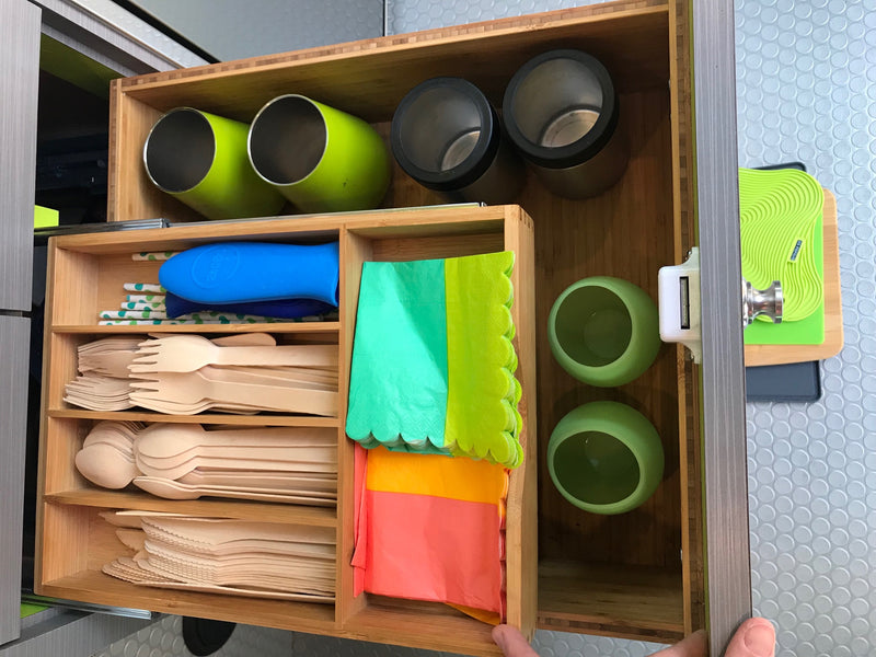 RV rental's smart kitchen drawer featuring organized wooden cutlery, colorful napkins, reusable cups, and paper straws. — photo 10