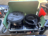 RV rental cooking: Eureka! camp stove with Woodsport cast iron Dutch oven & skillets ready for meals outdoors.