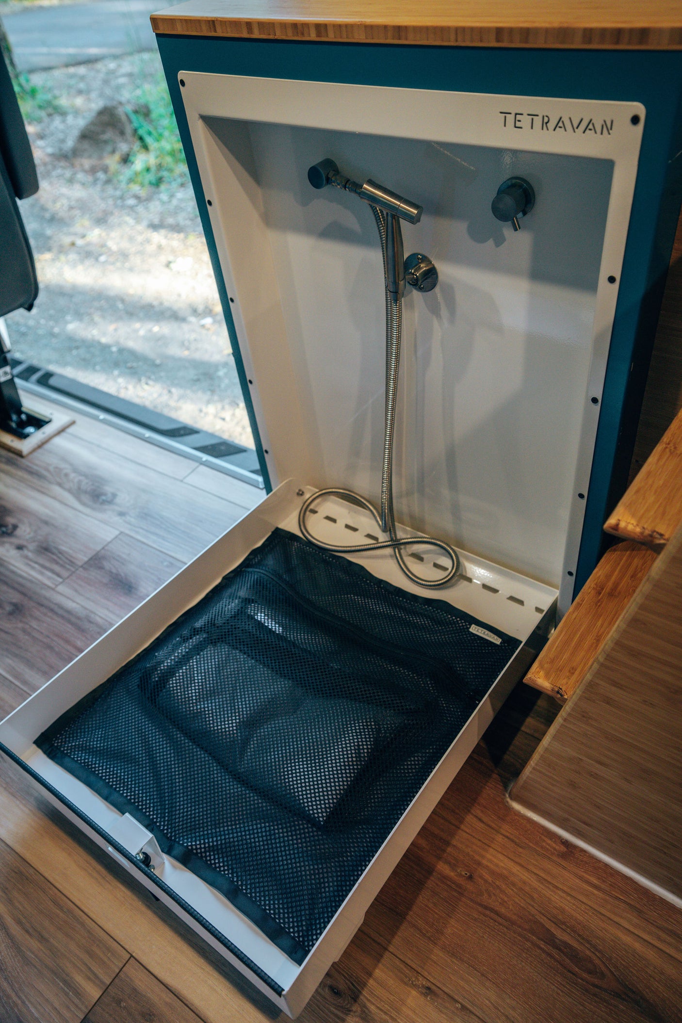 This RV rental features a compact TETRAVAN portable shower with a mesh floor for convenient, space-saving bathing on the go.