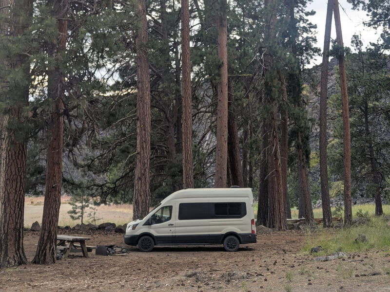  and control panels on a tiled backsplash. A window offers a scenic view.|Modern RV rental interior with a dining area — photo 17
