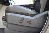 Close-up of a comfortable passenger seat in an RV rental, showing power adjustment controls and black leather.