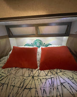 RV rental bedroom features: rust pillows, patterned bedding, and a green leaf-patterned headboard.