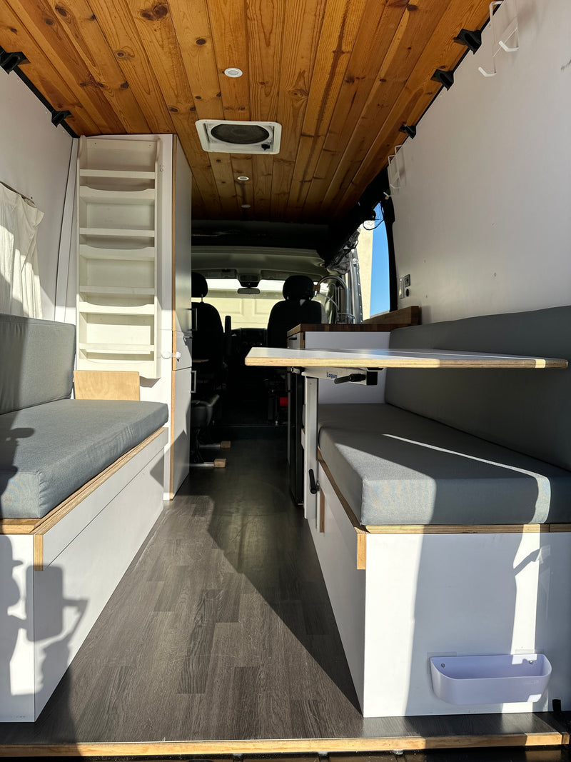 Functional custom van conversion for RV rental: wood ceiling, bench seating, and versatile table. Ready for mobile adventures. — photo 15