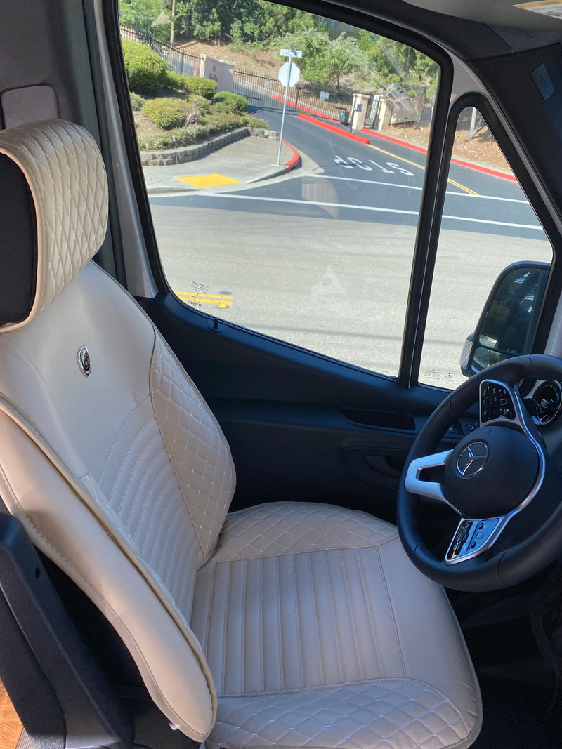Inside an RV rental: luxurious cream quilted driver's seat and Mercedes-Benz steering wheel, with street view visible. — photo 2
