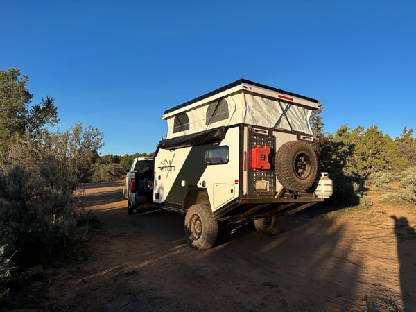 Adventure rv rental with flat tire, parked off-road in a desert camp. Truck hitched to trailer under clear blue sky. — photo 20
