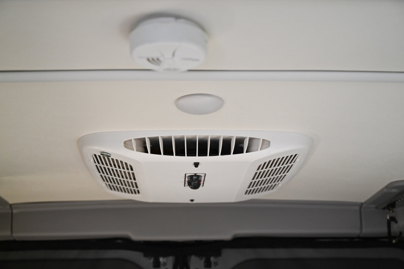 RV rental ceiling: A white AC unit, round light, and smoke detector are visible in the vehicle's interior.