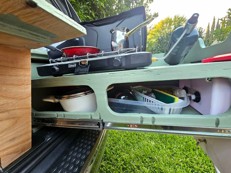 RV rental outdoor kitchen: Camping stove, cookware, and water tank on a pull-out setup for outdoor cooking. — photo 18