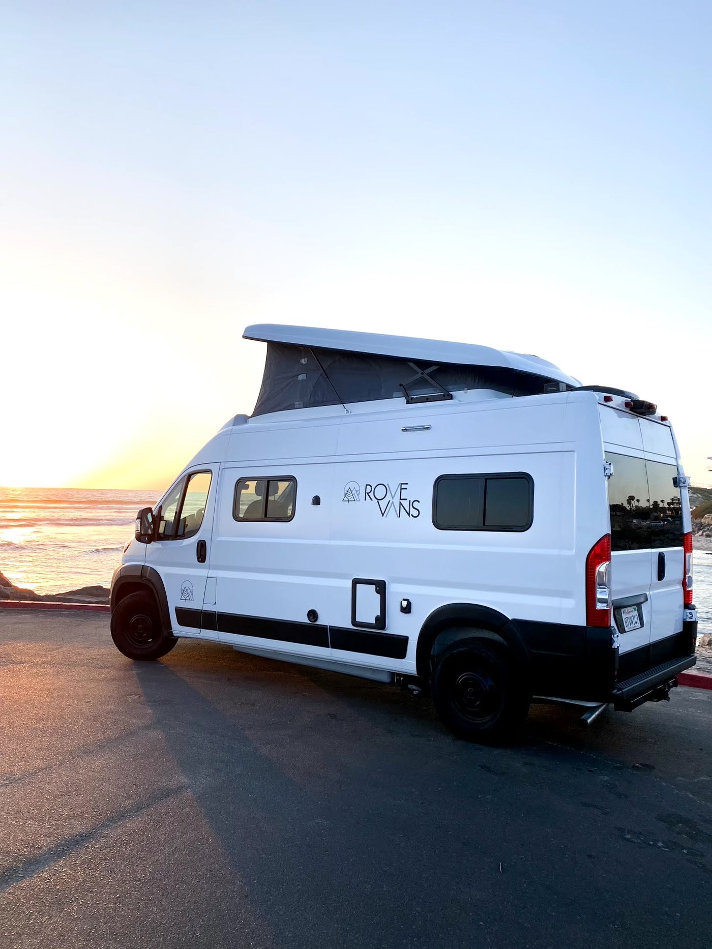 White Rove Vans pop-top camper van parked seaside at sunset. Ideal for an rv rental coastal escape. — photo 16