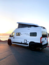 White Rove Vans pop-top camper van parked seaside at sunset. Ideal for an rv rental coastal escape.