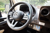 Luxury Mercedes-Benz RV rental interior, showing the steering wheel, dashboard, and advanced control panel.