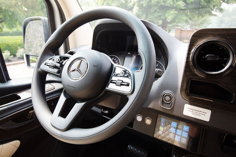 Luxury Mercedes-Benz RV rental interior, showing the steering wheel, dashboard, and advanced control panel.