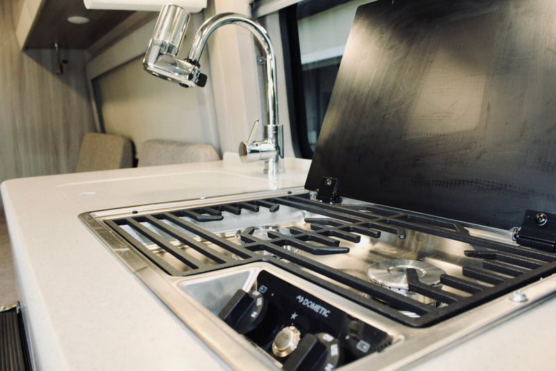 and central storage.|Modern RV rental interior: cozy living area with convertible seating — photo 6