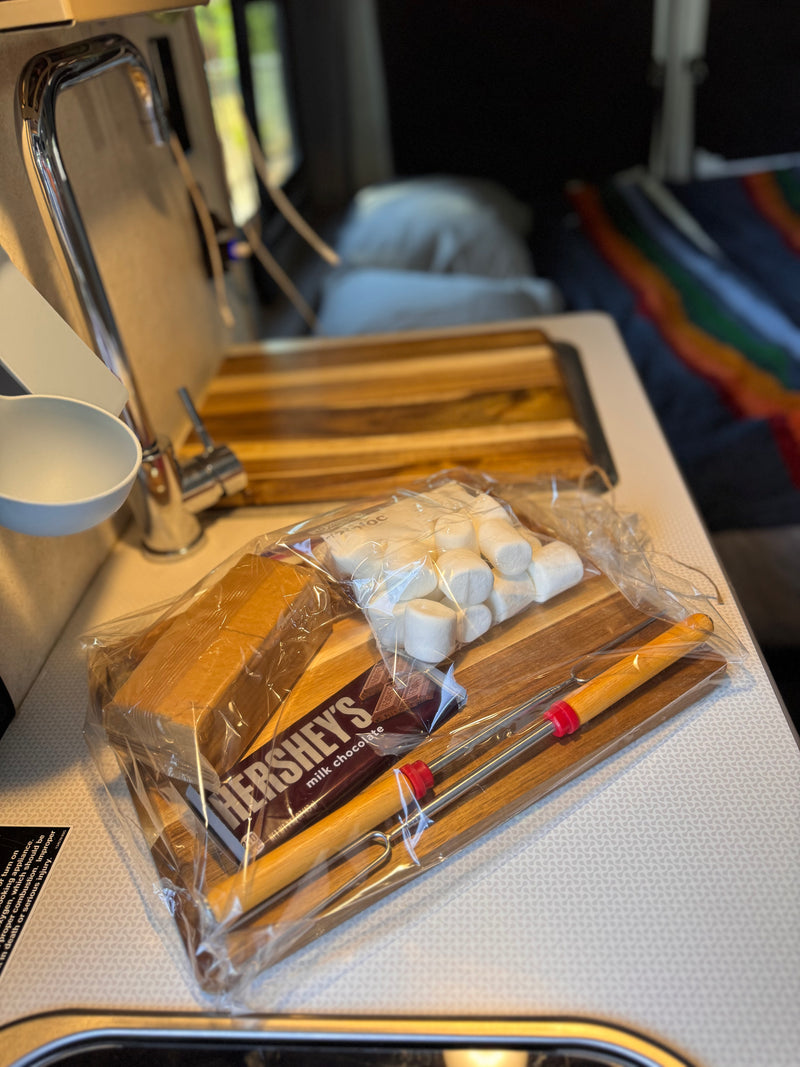 An RV rental counter holds a s'mores kit with Hershey's chocolate, marshmallows, graham crackers, and roasting sticks. — photo 2