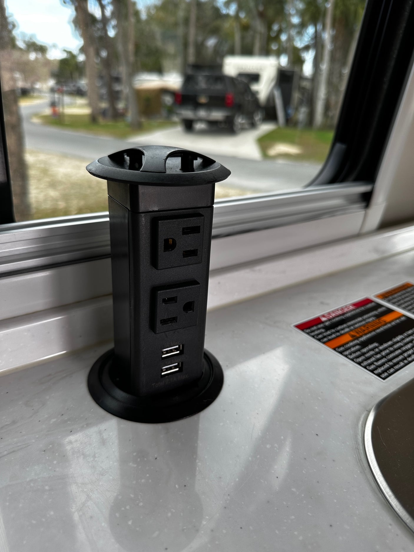 RV rental interior: A convenient pop-up power outlet with AC and USB ports in the countertop for charging devices.