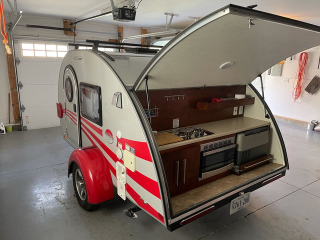  parked on a wet street. Ready for your next adventure.|Compact teardrop camper RV rental with open rear hatch