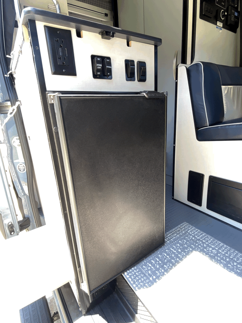 This RV rental offers a well-equipped interior with fridge, power outlets, awning controls, and dinette for comfortable travel. — photo 9