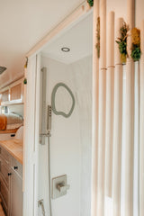 Experience comfort in this modern RV rental's chic shower and functional interior, perfect for compact travel.