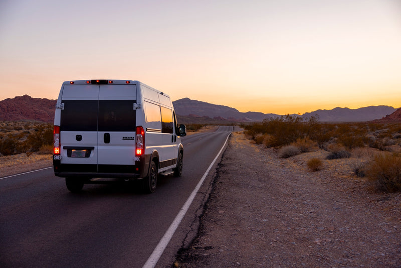 White RV rental van on a desert road at sunset, framed by mountains. Your ideal vehicle for scenic road trips & adventures. — photo 11