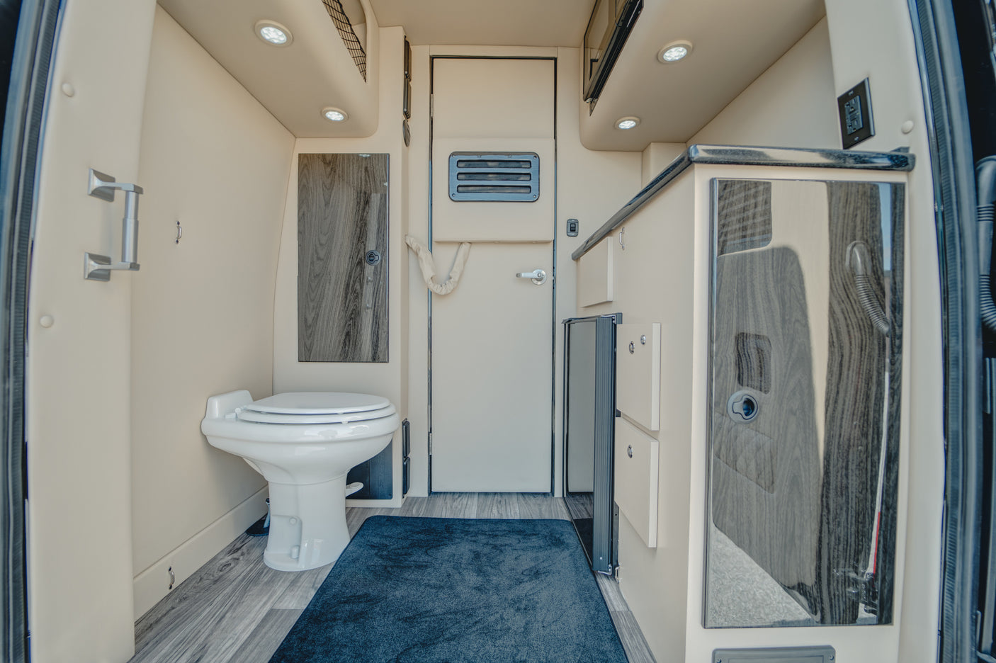 Explore this RV rental's cozy interior, featuring a built-in toilet, compact kitchen, and smart storage solutions.
