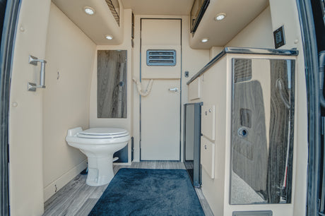 Explore this RV rental's cozy interior, featuring a built-in toilet, compact kitchen, and smart storage solutions.