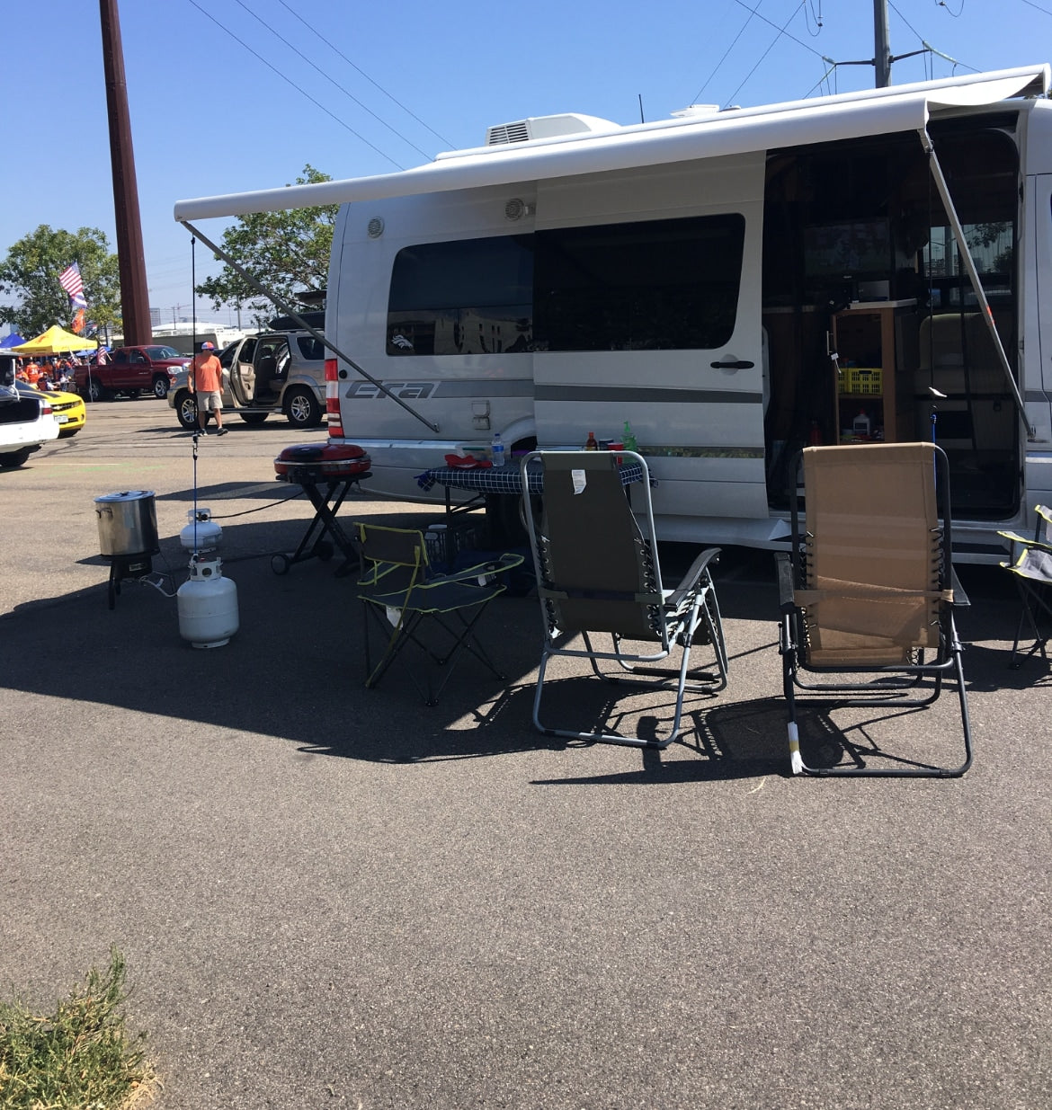 RV rental setup for a tailgate event with grill, chairs, and cooking gear. Perfect for outdoor leisure. — photo 9