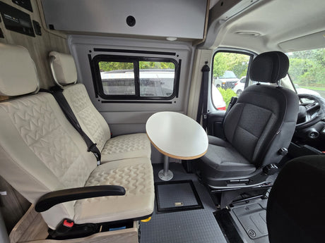 Spacious RV rental interior featuring comfy seats, a versatile table, and a clean, modern design for travel comfort.