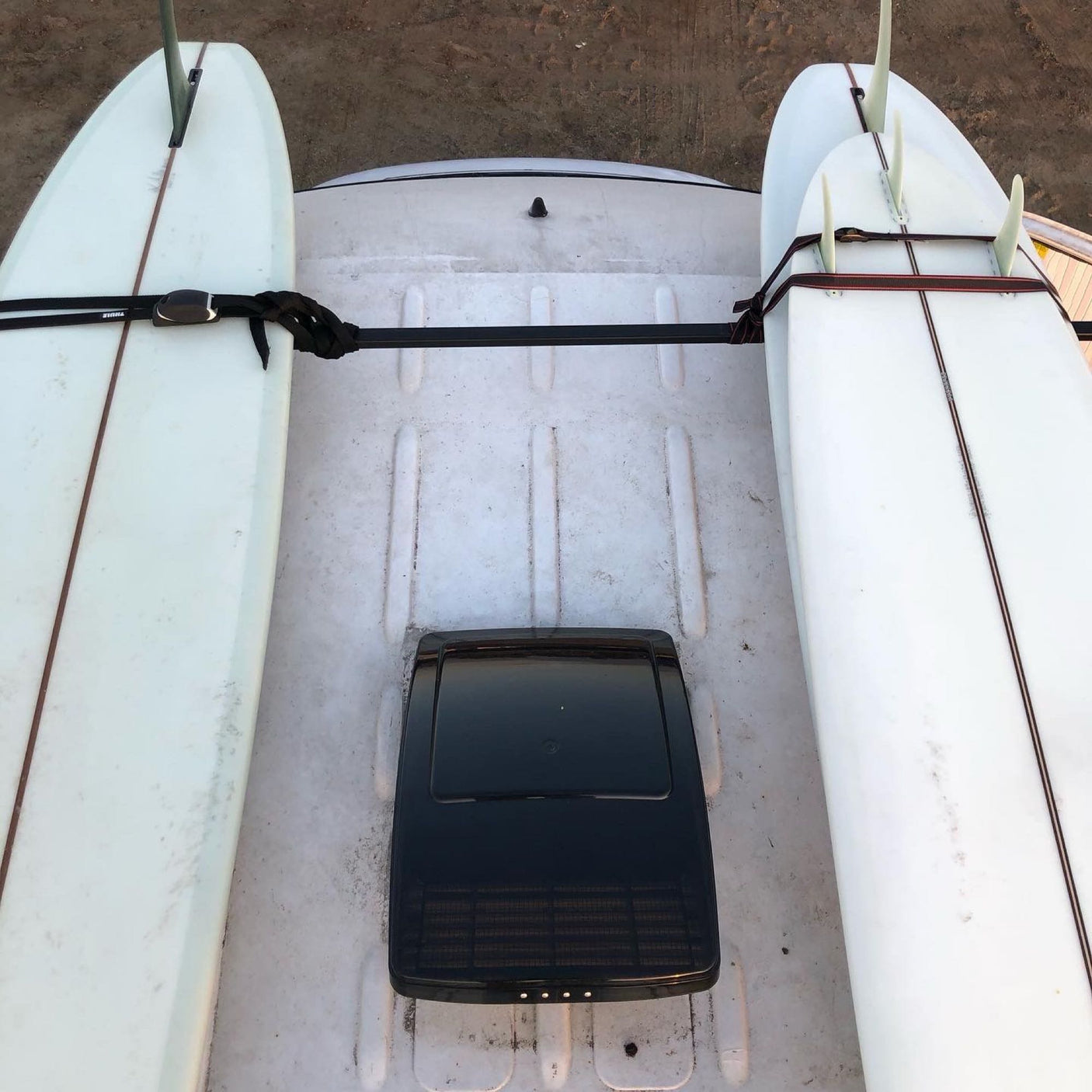 RV rental roof with surfboards securely strapped, showing a vent, ready for a beach adventure.