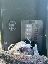 RV rental control panel: 12V DC switches for cabin lights & accessories, 12V outlets, and Victron battery monitor at 13.71V.