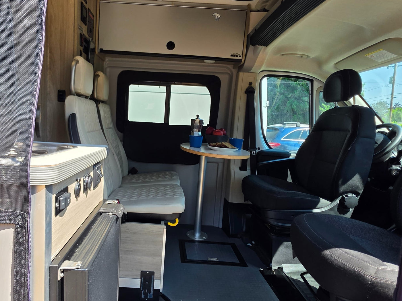  and modern quilted seats are ready for travel.|White Winnebago Solis camper van rv rental. Rear view displays pop-top — photo 7