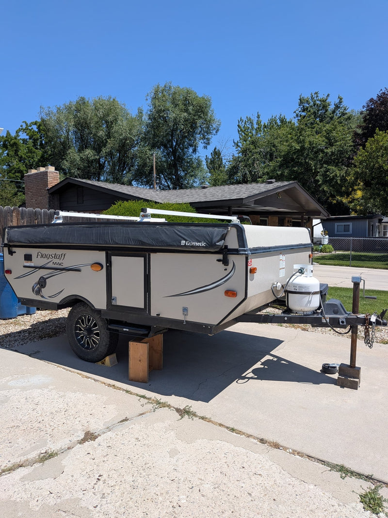  parked on a sunny street with its awning and grill visible.|Fully expanded Flagstaff pop-up camper — photo 7