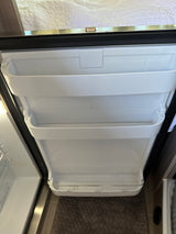 Open RV rental refrigerator door showing compact interior shelves and storage. Ready for your trip!