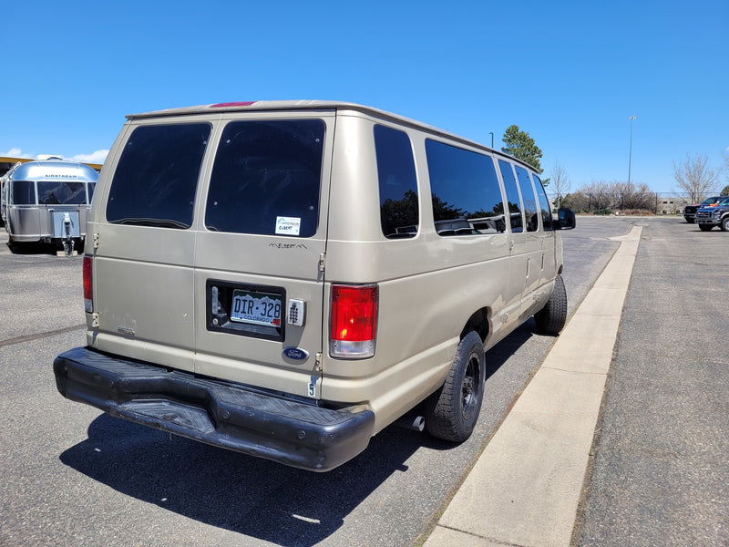 A tan Ford camper van (possible rv rental) is parked near a silver Airstream, ready for adventure. — photo 8