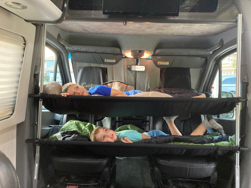  parked outdoors on a sunny day.|Enjoying an RV rental. A black Airstream camper van with awning out — photo 10
