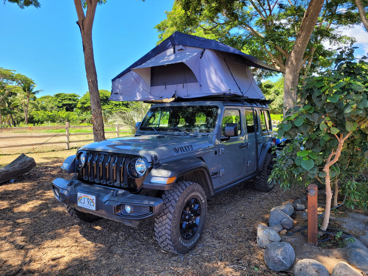 A gray Jeep Wrangler, equipped with an open rooftop tent, serves as a unique RV rental alternative for Hawaii camping adventures. — photo 14