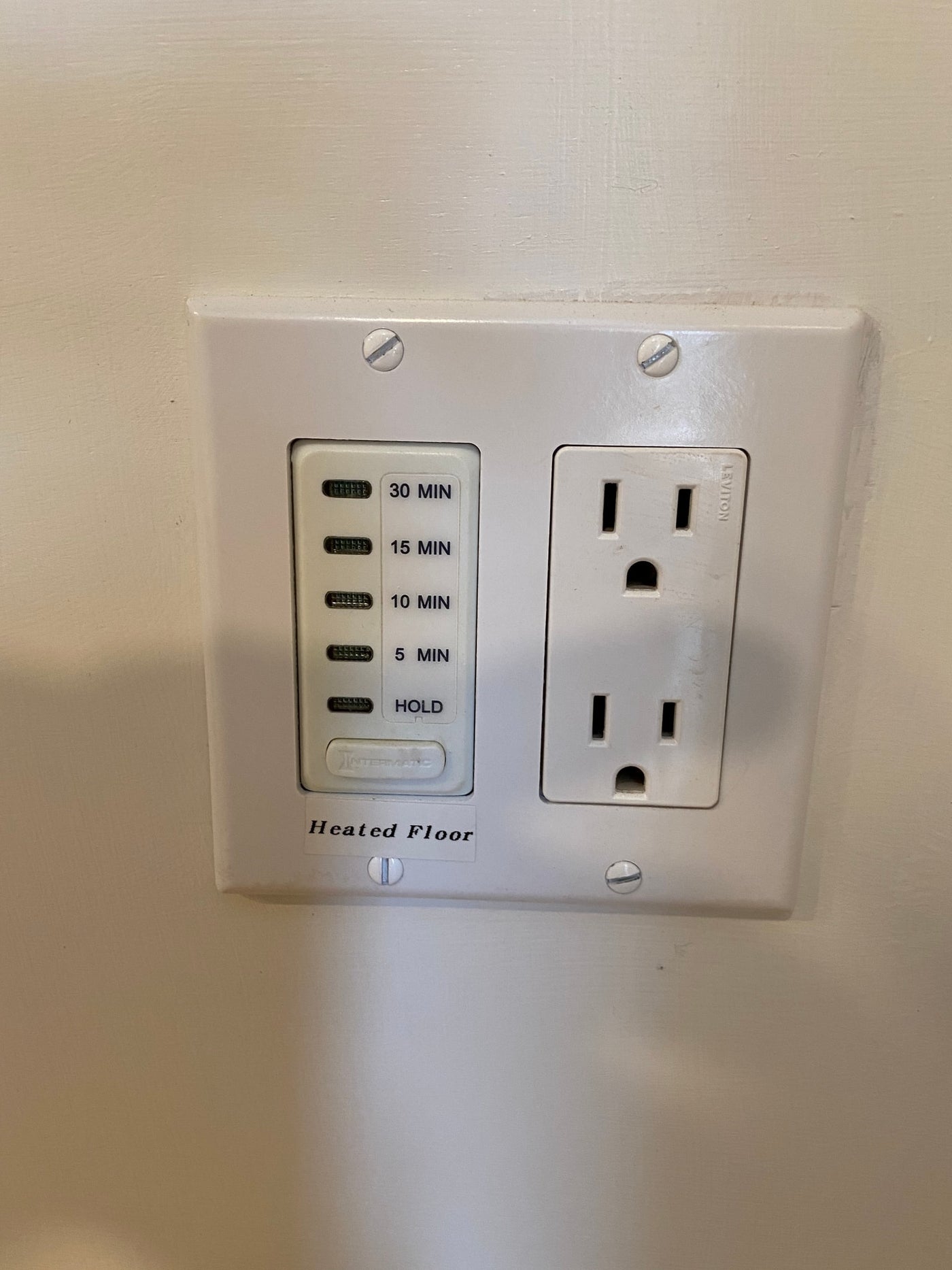 White wall plate in an RV rental with an electrical outlet and a timer (30, 15, 10, 5 min, Hold) for a heated floor. — photo 17