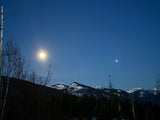 Explore tranquil moonlit mountains & dark skies by RV rental. Witness nature's beauty under two celestial bodies.